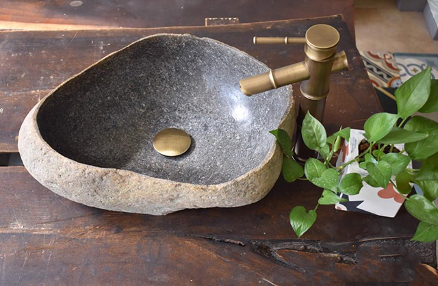 Bồn rửa tay bằng đá cuội kết hợp cùng vòi đồng mang đến nét cổ xưa